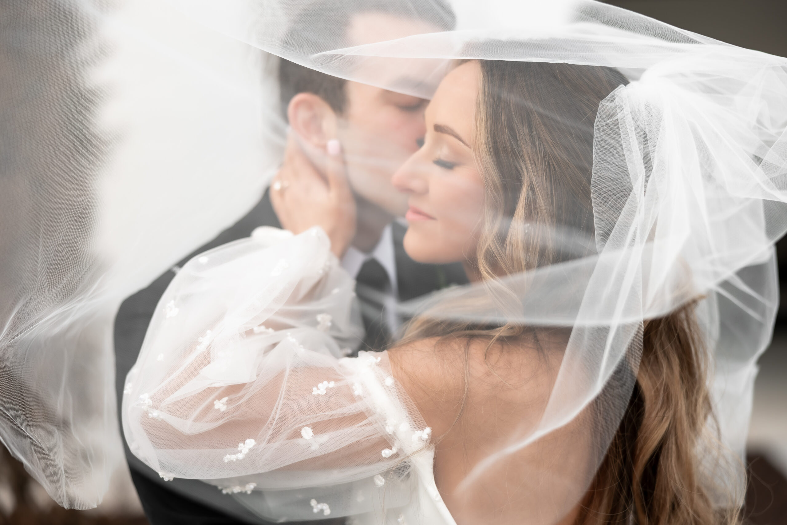 Bride and Groom under the veil in front of the Grand at Willow Springs